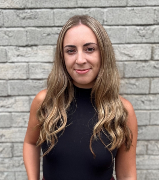 Headshot of Kristy Allen smiling in front of a stone building.