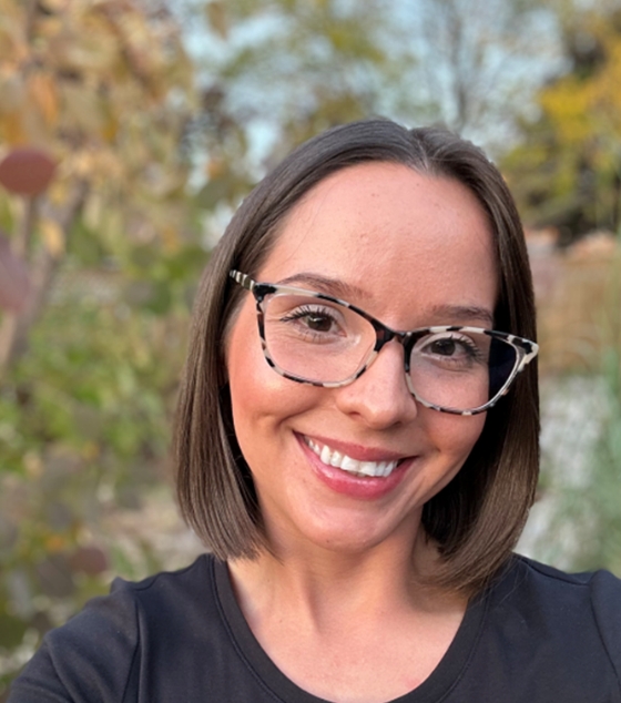 Headshot of Stephanie Junes smiling with trees in the background.