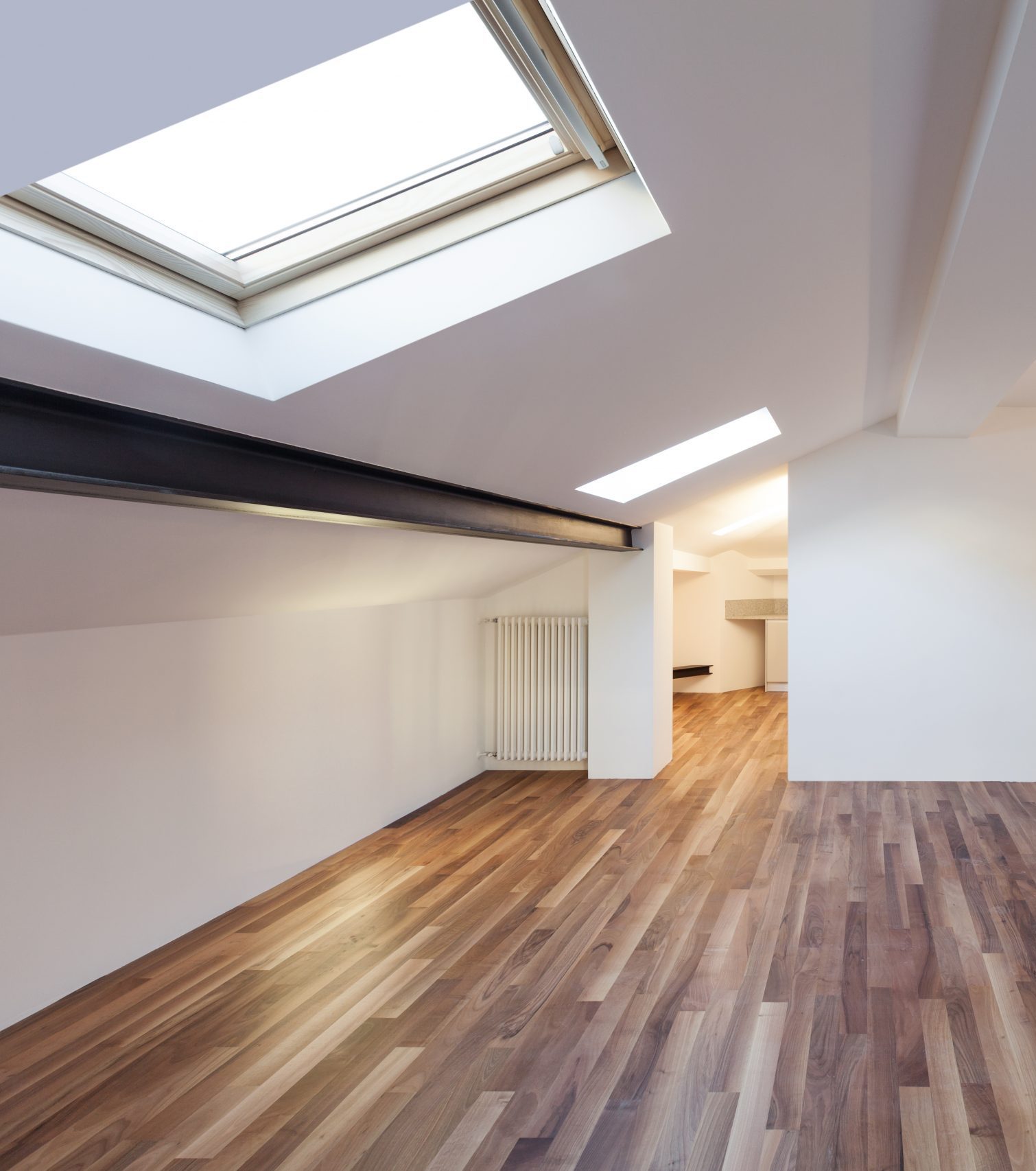 An empty loft room with a ceiling window.