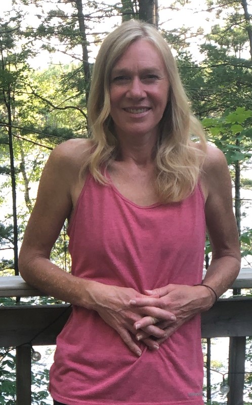A headshot of Salinda Horgan smiling and standing in front of trees.