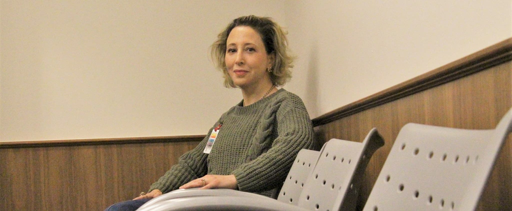 Dr. Mara Muraven sitting on a chair and posing for a headshot.