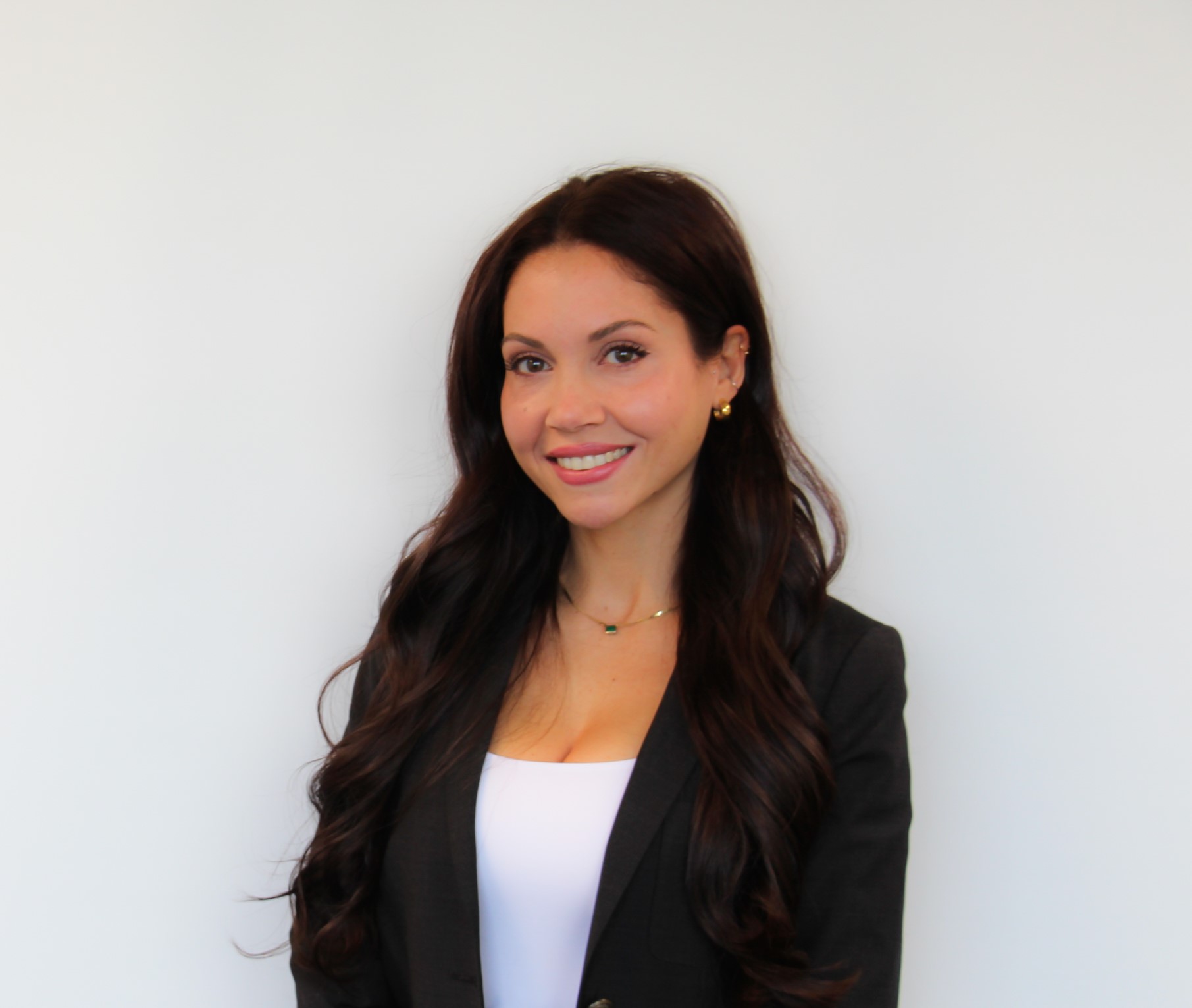 Sevil Deljavan smiling in front of a white background.