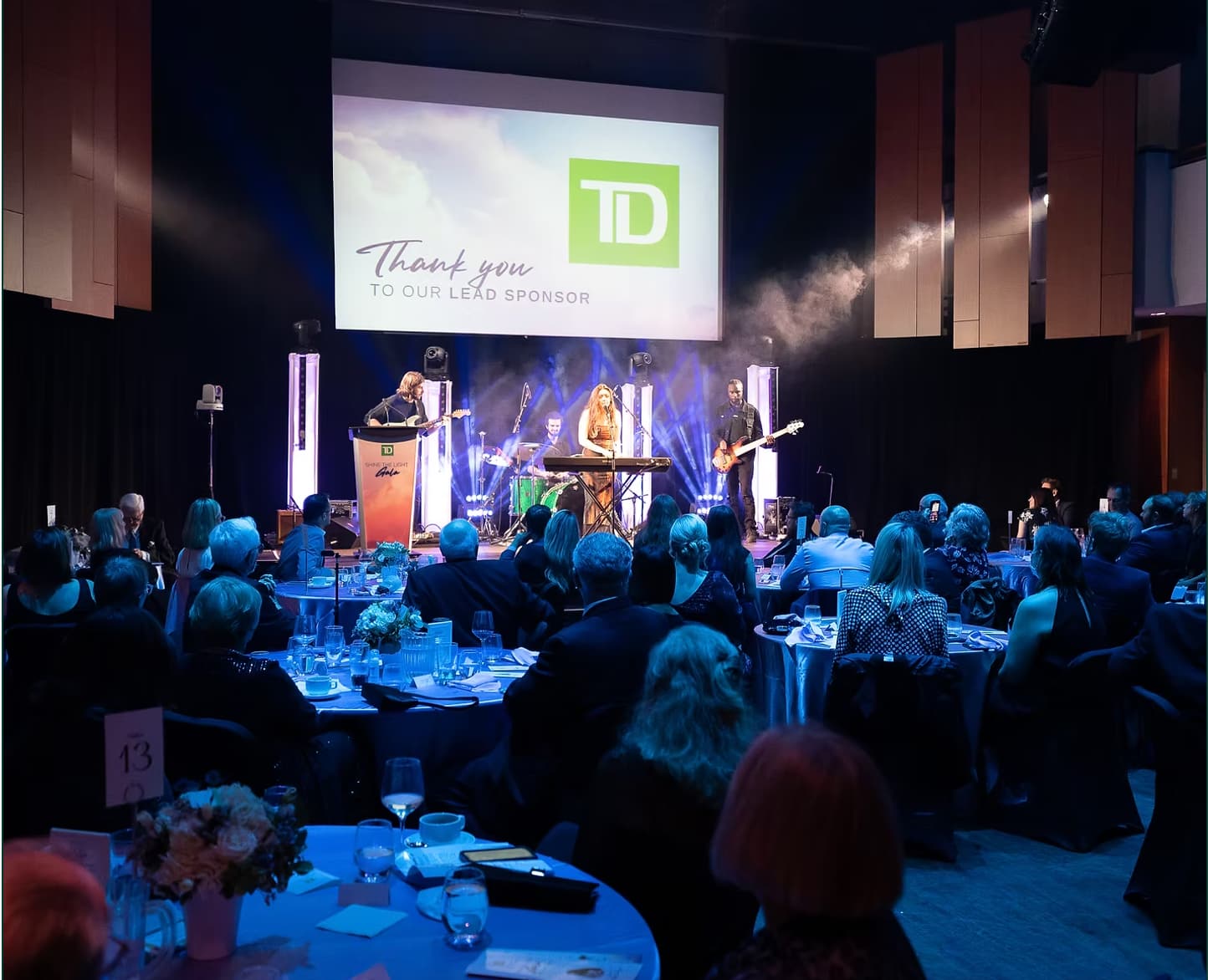 A band plays on stage in a dark venue.